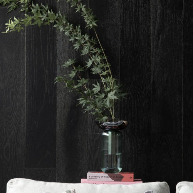Prism Vase is a glass vase with a sea green base and a removable dirty purple flute or funnel. Green stems are on display here