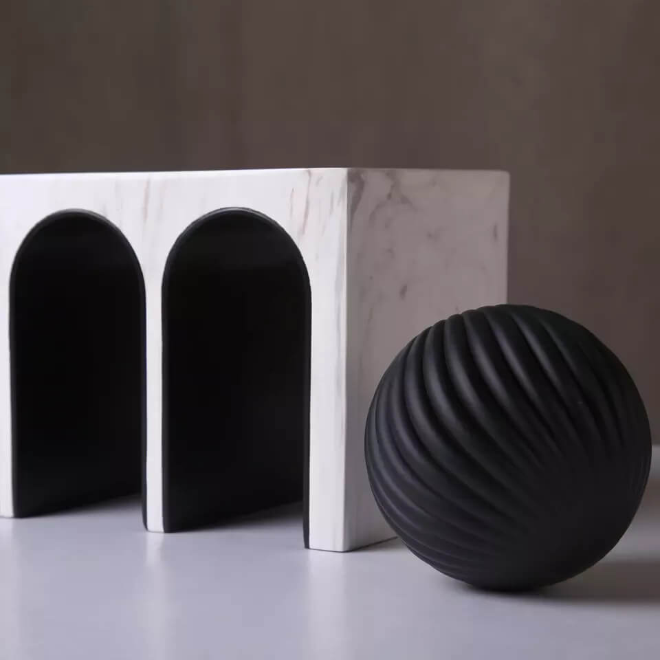 Triple Arched object made from resin and marble. A ball object sits on the top of the sculpture.