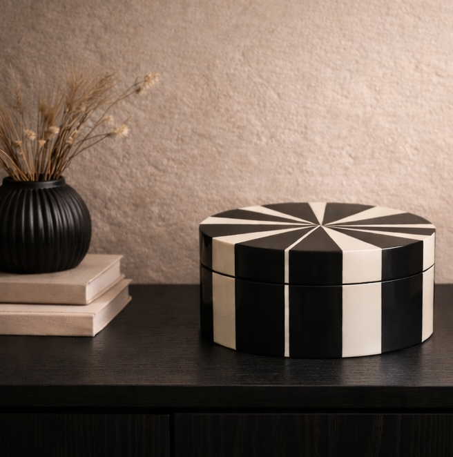 Black and white geometric-patterned box on a dark surface with a neutral background