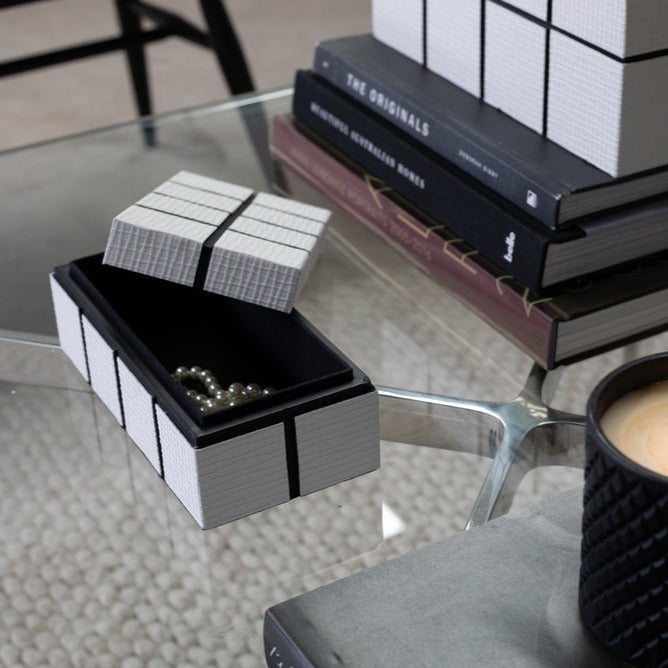 Storage white boxes with grid lines embossed with the small box lid open 