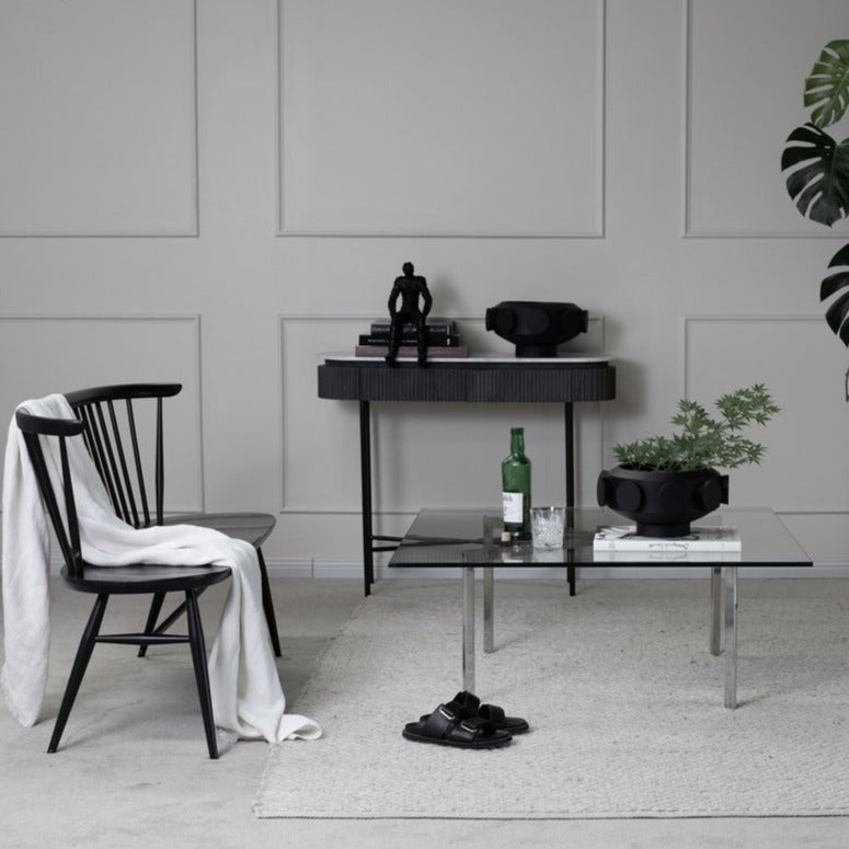 A resin large pedestal bowl with black cylinders on the exterior or perimeter